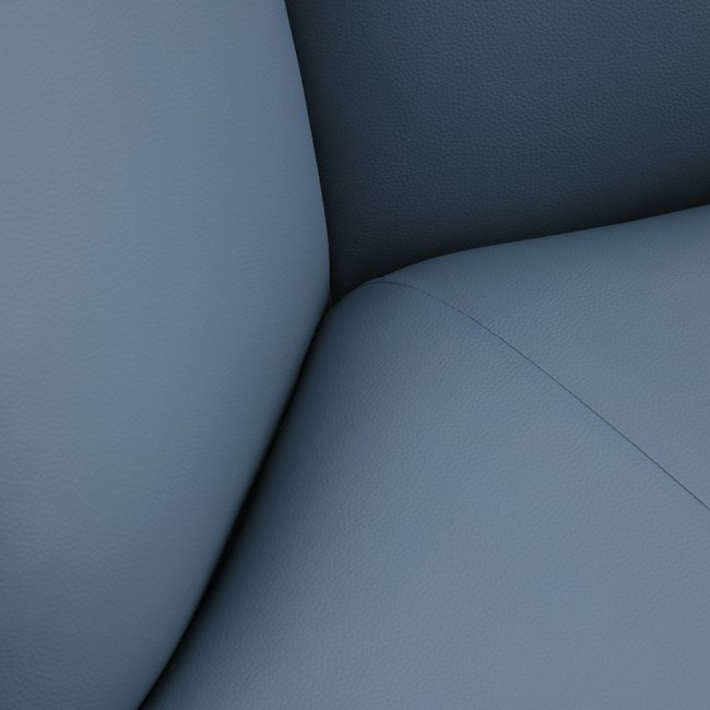 Contemporary lounge chair with soft blue upholstery, cushioned armrests, and curved black metal frame – designed for comfort in upscale hospitality or commercial spaces